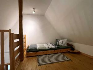 Dormitorio pequeño con cama en el ático en Ferienwohnung Thorge OG Hof Döttgebüll, en Aventoft 14 fotos más