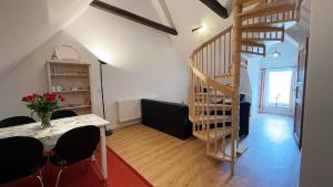 Una sala de estar con una escalera y una mesa y sillas. en Ferienwohnung Sina OG Hof Döttgebüll, en Aventoft