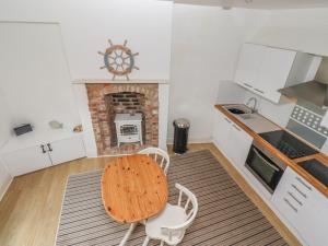 a kitchen with a table and chairs and a fireplace at Seafield Coach House in Alnwick +18 photos