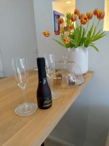 eine Flasche Wein und zwei Gläser auf dem Tisch in der Unterkunft Beach House Rodine - free parking & bikes in Scheveningen