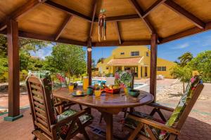 a wooden table and chairs on a patio at Sunny Paradise Villa in Noord