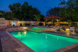 a swimming pool at night with a gazebo at Sunny Paradise Villa in Noord