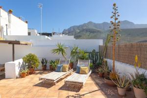 a patio with two lounge chairs and potted plants at Charming house with Rooftop Pool in Agaete