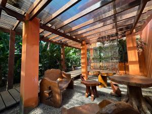 a wooden pergola with a table and a bench and a table and chair at Pousada Sunset in Itacaré