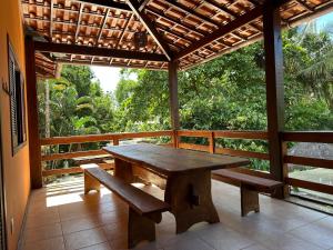 a wooden table and benches on a porch at Pousada Sunset in Itacaré