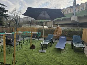 维也纳Superb 2BR Apt Very Spacious At the Millenium Tower的草地上带椅子和遮阳伞的庭院