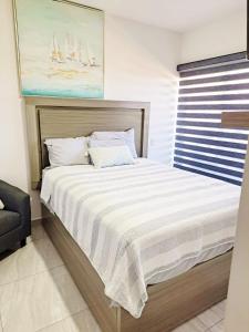 a bedroom with a large bed with white sheets at Marina Cerritos Azul Turquesa #3 - 4 Albercas - 1 Min Playas in Mazatlán +24 photos