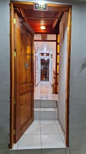 a hallway with a wooden door and stairs at Bercy in Arica