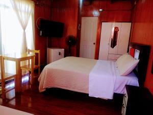 a bedroom with a white bed and a television at Bercy in Arica