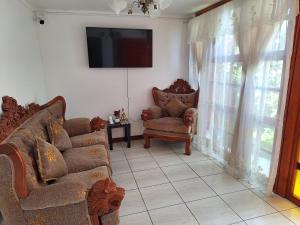 a living room with a couch and a tv on a wall at Bercy in Arica