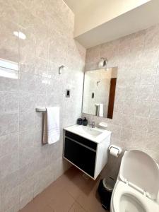a bathroom with a toilet and a sink and a mirror at Urbano San Juan in San Juan