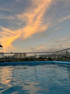 a swimming pool with a sunset in the background at CasaCabaña in Santa Marta