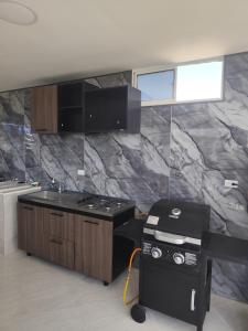 a kitchen with a counter and a sink and a stove at CasaCabaña in Santa Marta
