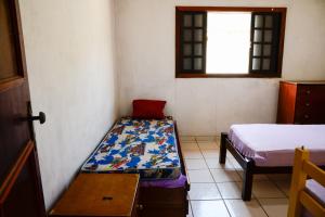 a small room with two beds and a window at Casa com otima localizacao e churrasqueira in Ilhabela