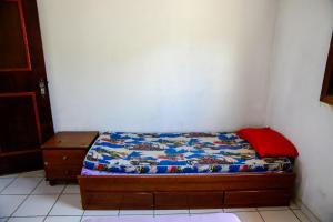 a small bed in a corner of a room at Casa com otima localizacao e churrasqueira in Ilhabela +22 photos