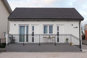 a white house with a balcony at Apartments BINGO - Zagreb airport in Velika Gorica