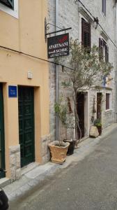 un edificio con un letrero al lado de una calle en Guesthouse Ivan en Skradin