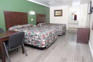 a hotel room with two beds and a table at Starlite Motel in San Antonio