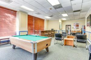 a pool table in a room with chairs at Downtown Studio with City Views in Jacksonville! in Jacksonville