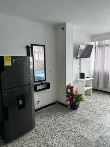 a room with a black refrigerator and a vase of flowers at Laguito Suites Cartagena in Cartagena de Indias
