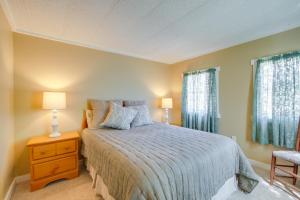 a bedroom with a bed and two windows at Steps to Tunica Lake Outdoor Retreat with Fire Pit in Tunica