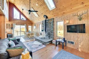 Il comprend un salon doté d'un canapé, d'une télévision et d'une cheminée. dans l'établissement 3 Mi to Catskill Trail Stamford Cottage with Views, à Stamford