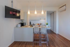 a kitchen with two bar stools and a counter at A Ca' di Chiara e Fabio - Panoramica Lago Maggiore in Lesa