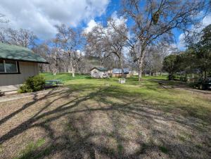 a large yard with trees and a house at Squaw Valley Motel Room 7 in Dunlap