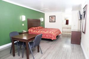 a hotel room with a bed and a table and chairs at Starlite Motel in San Antonio