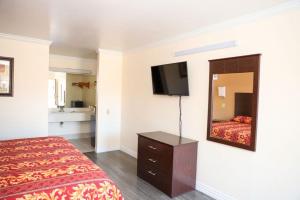 a hotel room with a bed and a mirror at Starlite Motel in San Antonio