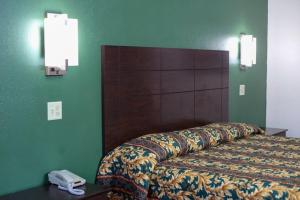 a hotel room with a bed and a phone on a table at Starlite Motel in San Antonio +21 photos