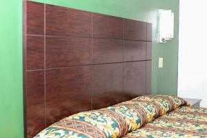 a large wooden headboard on a bed in a room at Starlite Motel in San Antonio