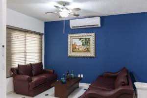 a living room with a couch and a ceiling fan at Downtown Villa for 7 guests, access to pool! in Cancún