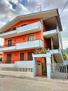 un edificio arancione con una recinzione bianca di fronte di Le mimose ad Alba Adriatica