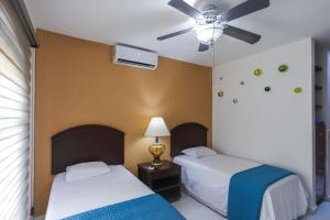 a bedroom with two beds and a ceiling fan at Downtown Villa for 7 guests, access to pool! in Cancún +47 photos