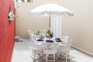 a table with white chairs and an umbrella at Downtown Villa for 7 guests, access to pool! in Cancún