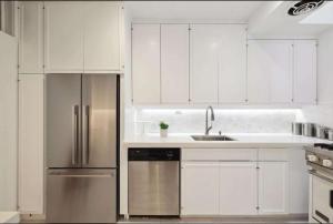 eine Küche mit weißen Schränken und einem Edelstahlkühlschrank in der Unterkunft Nob Hill Charm in San Francisco