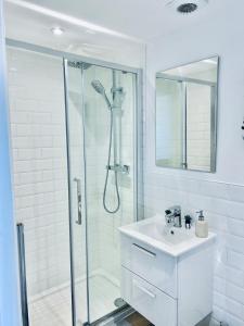 a white bathroom with a shower and a sink at Folkestone Harbour Modern Comfortable Flat F3 in Folkestone +28 photos