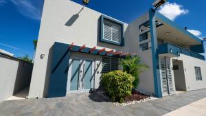 多拉多Private 7 Villa Complex with 16 BR Pool & Jacuzzi的白色和蓝色的房子,有车道