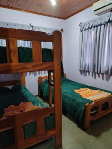 a bedroom with two bunk beds in a house at Cabañas Posta Valentin in Puerto Iguazú