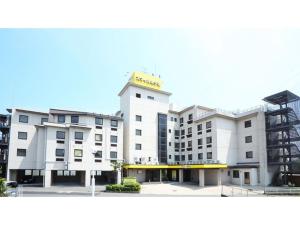 郡山市にあるSmile Hotel koriyama - Vacation STAY 61210vの黄色の看板が立つ白い大きな建物
