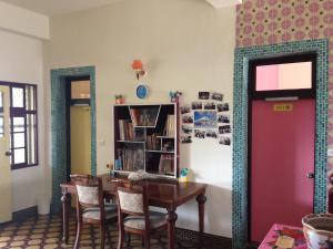 uma sala de jantar com uma mesa e um espelho em Go home backpackers em Huxi