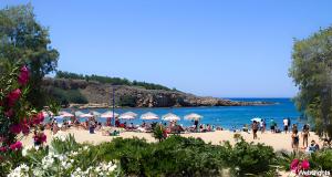 people on a beach with umbrellas and the ocean at Ammos Family Villa in Daratso