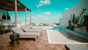 - une piscine avec des chaises longues blanches sur la terrasse dans l'établissement Departamento 304 by Rotamundos, à Playa del Carmen 21 autres photos