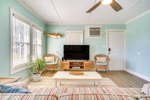 Una sala de estar con televisión y un sofá. en 1 Mi to Cypremort Point Waterfront Gem with Dock!, en Franklin