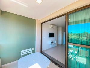 a room with a view of a balcony with a television at Carneiros Beach Resort in Praia dos Carneiros