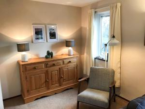 a room with a dresser and a chair and a window at Melbreak in Lorton +24 photos