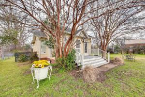 a house with a porch and a flower pot of flowers at Walk to Lake Chicot Cottage with Yard and Views! in Lake Village