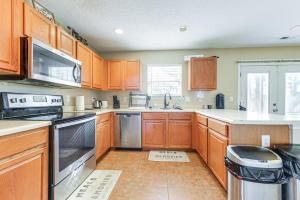 ローリーにある8 Mi to Dtwn Raleigh Family Home with Yardのキッチン(木製キャビネット、ステンレス製の電化製品付)