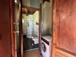 a bathroom with a toilet and a washing machine at LA CASA DEI SOGNI appartamento Gelsomino in Colazza